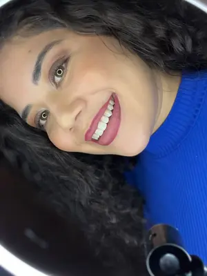 Mulher sorrindo com alegria contagiante e lábios vibrantes em destaque.