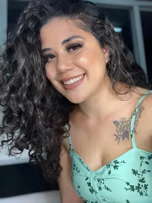 Sorriso radiante de uma mulher de alma leve, com toque natural e brilho sutil na pele.